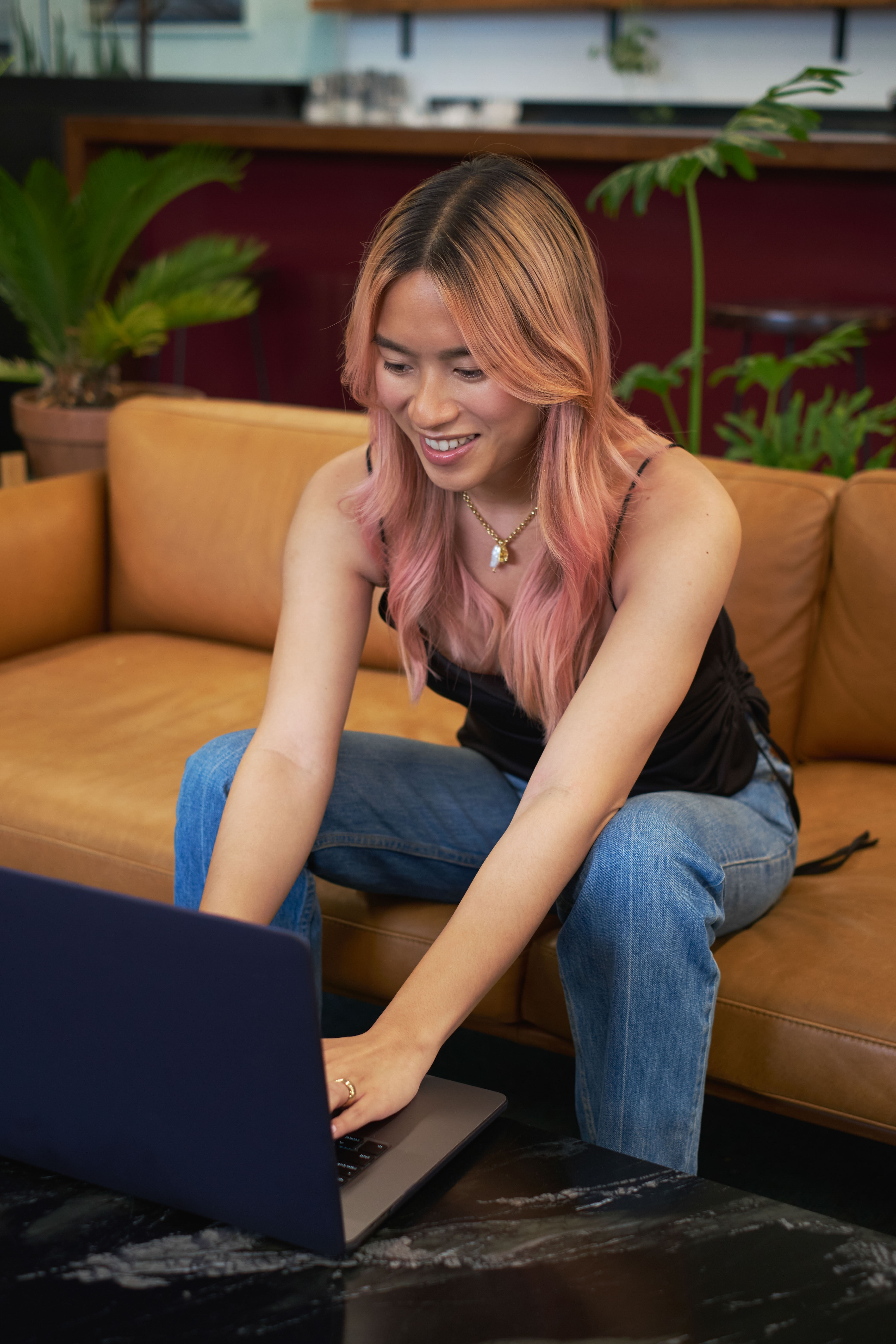 A transfeminine person using a laptop at work